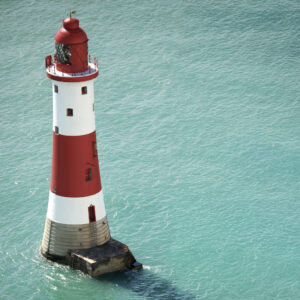 Fotografia di un faro bianco e rosso sul mare, simbolo di guida, orientamento e chiarezza interiore, usato da Michele Piantoni nella sezione coaching.